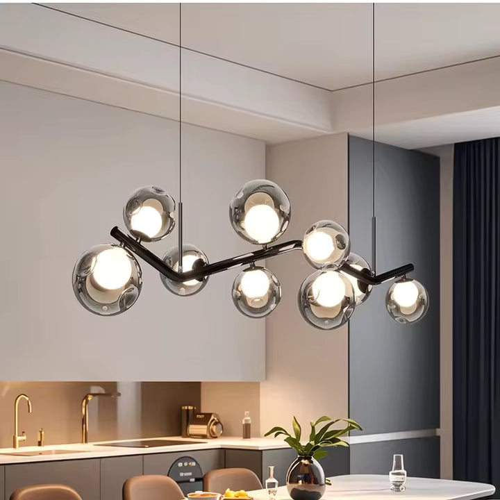 Lustre branche ondulante à globes en verre fumé, au design contemporain et sculptural au-dessus d’une table