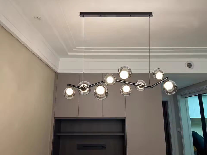 Lustre branche ondulante à globes en verre fumé, au style contemporain et élégant dans une pièce aux tons neutres