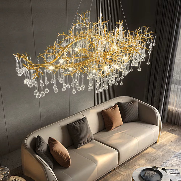Dans ce salon design, une suspension sculpturale à branches dorées et pampilles de cristal crée un décor spectaculaire