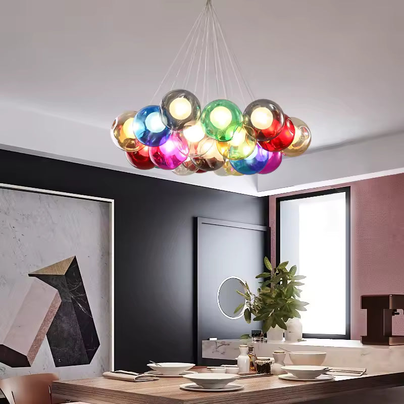 Au-dessus d'une table à manger, lustre original en grappes de bulles de verre coloré aux accents pop et contemporains.