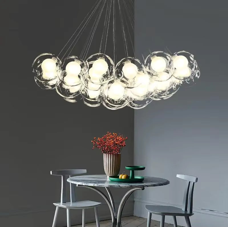 Dans une salle à manger minimaliste, un lustre aérien aux bulles de verre lumineuses forme une grappe sculpturale.