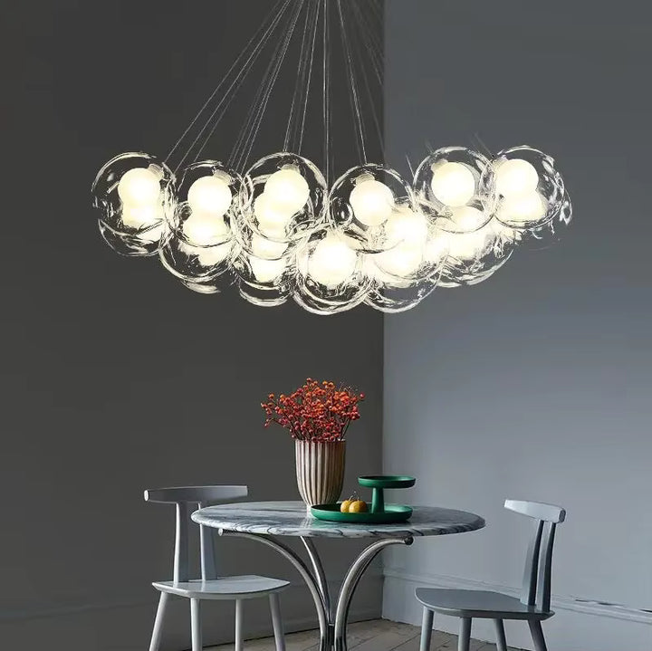 Dans une salle à manger minimaliste, un lustre aérien aux bulles de verre lumineuses forme une grappe sculpturale.