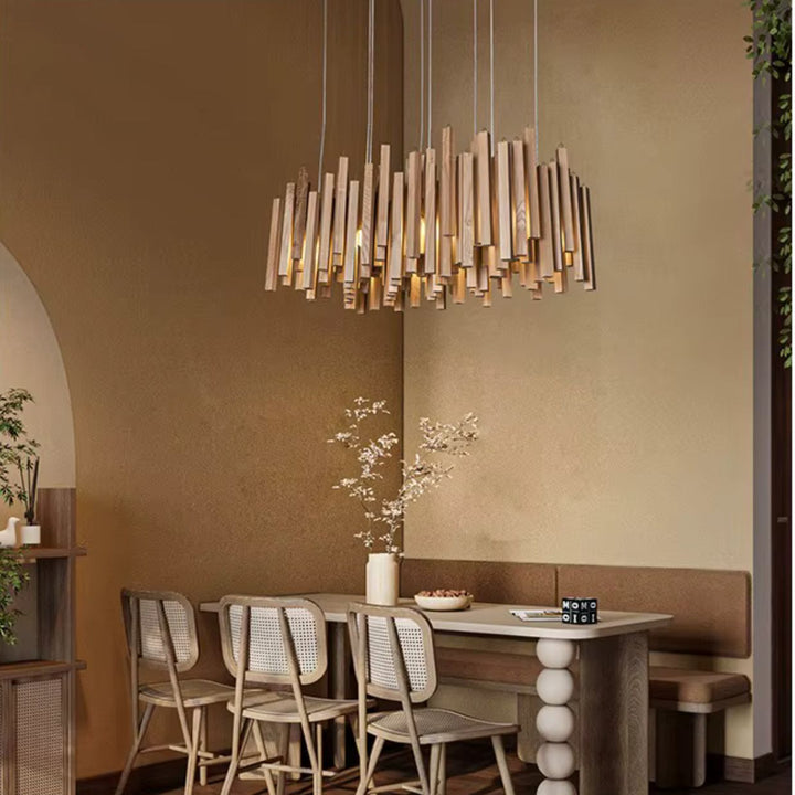 Lustre cascade en bois clair au style Japandi, suspendu au-dessus d’une table dans une salle à manger chaleureuse