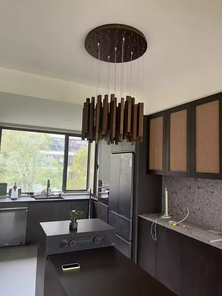 Grand lustre cascade en bois foncé au design naturel contemporain, suspendu dans une cuisine moderne avec îlot central