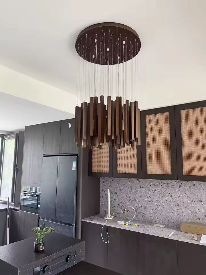 Lustre cascade en bois foncé au style contemporain, suspendu dans une cuisine moderne aux finitions chaleureuses