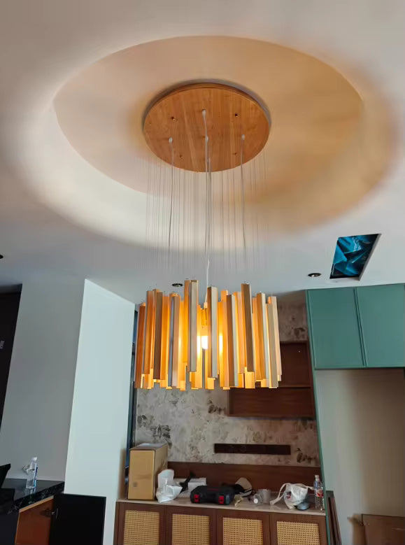 Lustre cascade en bois massif suspendu sous une rosace ronde, avec lumière chaleureuse et style naturel contemporain