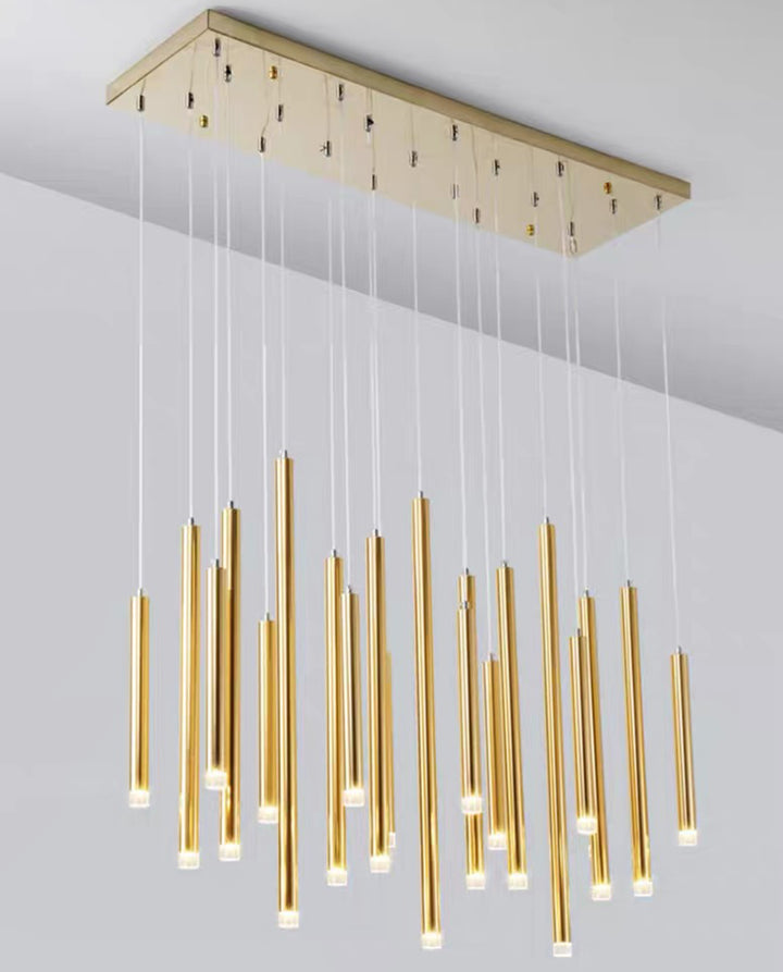 Lustre cascade doré à tubes suspendus de hauteurs variées dans un intérieur contemporain.