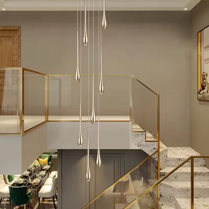 Dans un escalier à double hauteur, ce lustre cascade déploie ses gouttes dorées dans un style élégant et aérien