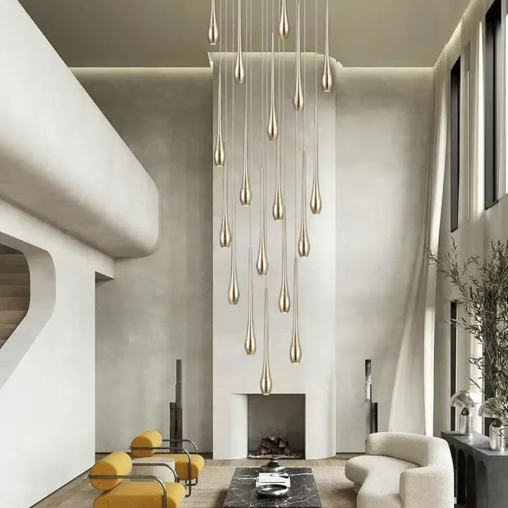 Dans un salon grande hauteur, ce lustre cascade de gouttes dorées crée une présence aérienne et sculpturale