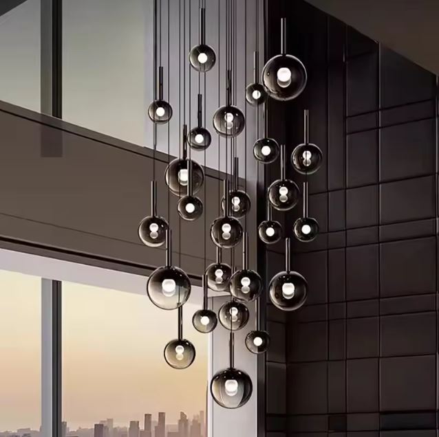 Lustre cascade à multiples globes en verre fumé noir, idéal plafond haut, style luxe contemporain.