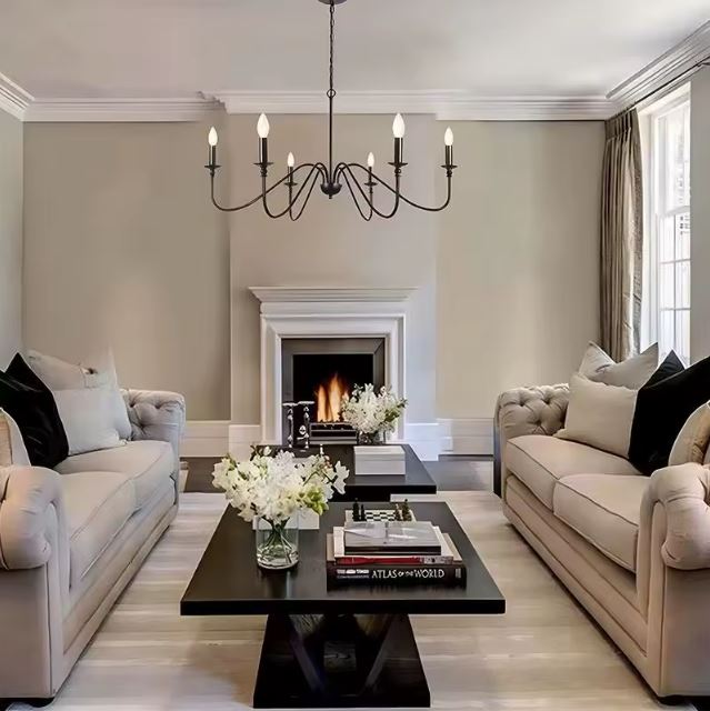 Lustre chandelier noir aux lignes élancées au style contemporain sophistiqué pour un salon chaleureux et raffiné.