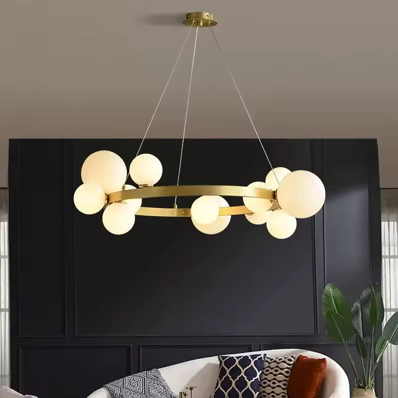 Un lustre circulaire doré à globes en verre opalin éclaire un salon élégant aux murs noirs, dans un esprit Art déco.