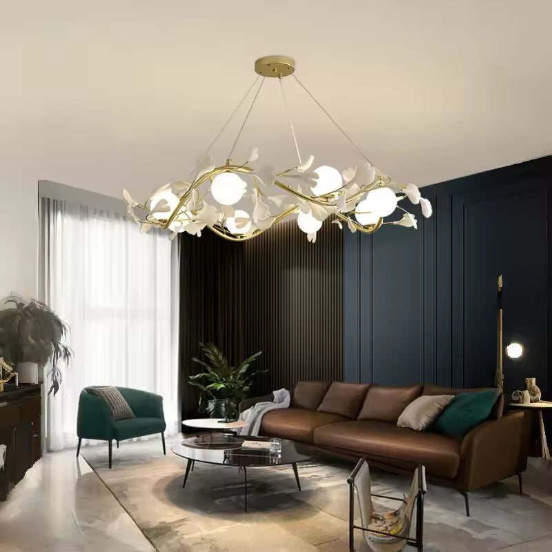 Dans un salon contemporain, lustre circulaire doré aux branches fleuries et globes opalins, au-dessus d'un canapé brun.