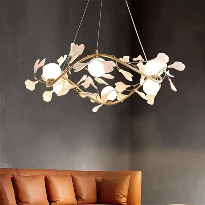 Au-dessus d'un canapé terracotta, lustre circulaire doré aux fleurs blanches et globes opalins, de style moderne et sculptural.