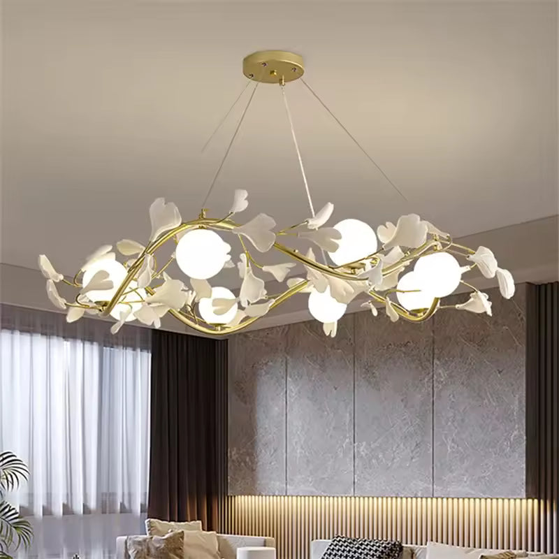 Lustre floral circulaire doré aux branches ornées de fleurs blanches et de globes opalins, au design contemporain.