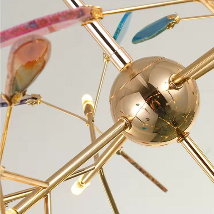 Détail du lustre coloré en agate naturelle avec structure dorée et branches au design artistique