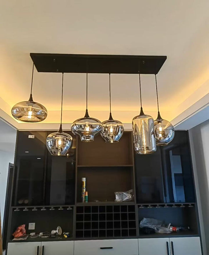 Lustre contemporain en verre fumé aux abat-jours aux formes uniques et variés.