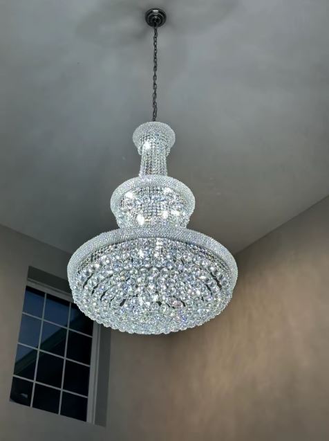 Lustre en cristal argenté suspendu en grande hauteur, style classique luxueux et éclat spectaculaire.