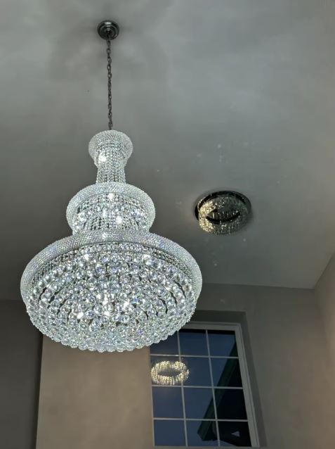 Lustre en cristal argenté suspendu, style classique élégant et volume généreux pour intérieur raffiné.