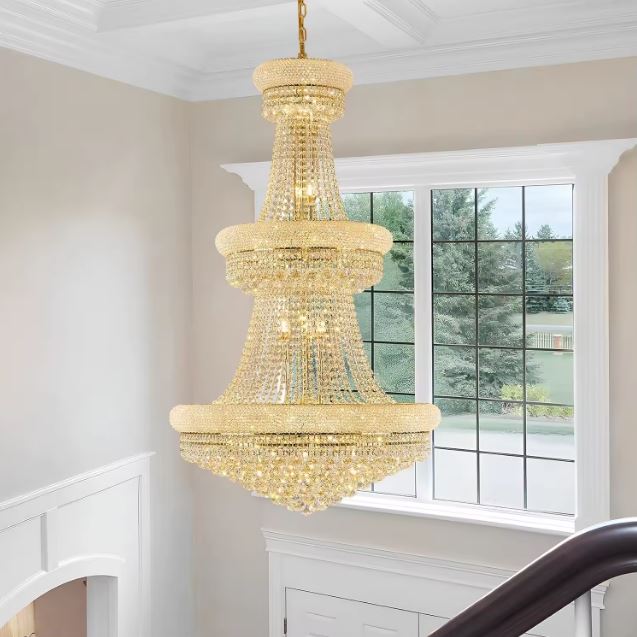 Lustre en cristal doré dans une cage d’escalier, style classique chic et silhouette majestueuse en hauteur.