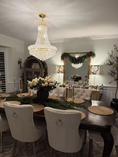 Lustre en cristal doré au-dessus d’une table de salle à manger, style classique raffiné et ambiance chaleureuse.
