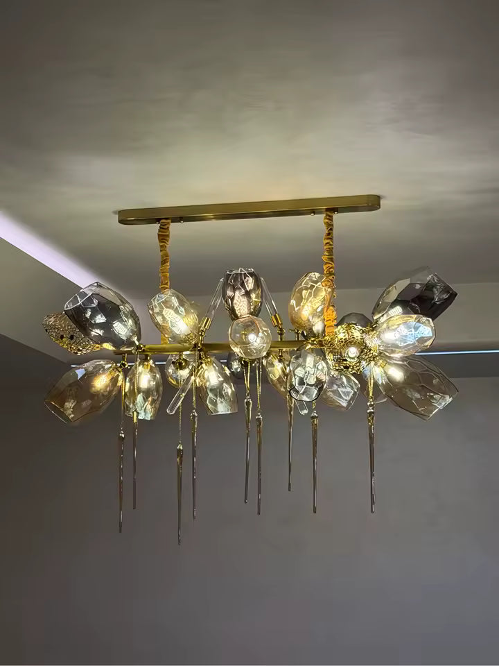 Composition linéaire en cristal fumé et doré, ornée de facettes irrégulières et de pampilles élancées au style luxueux.