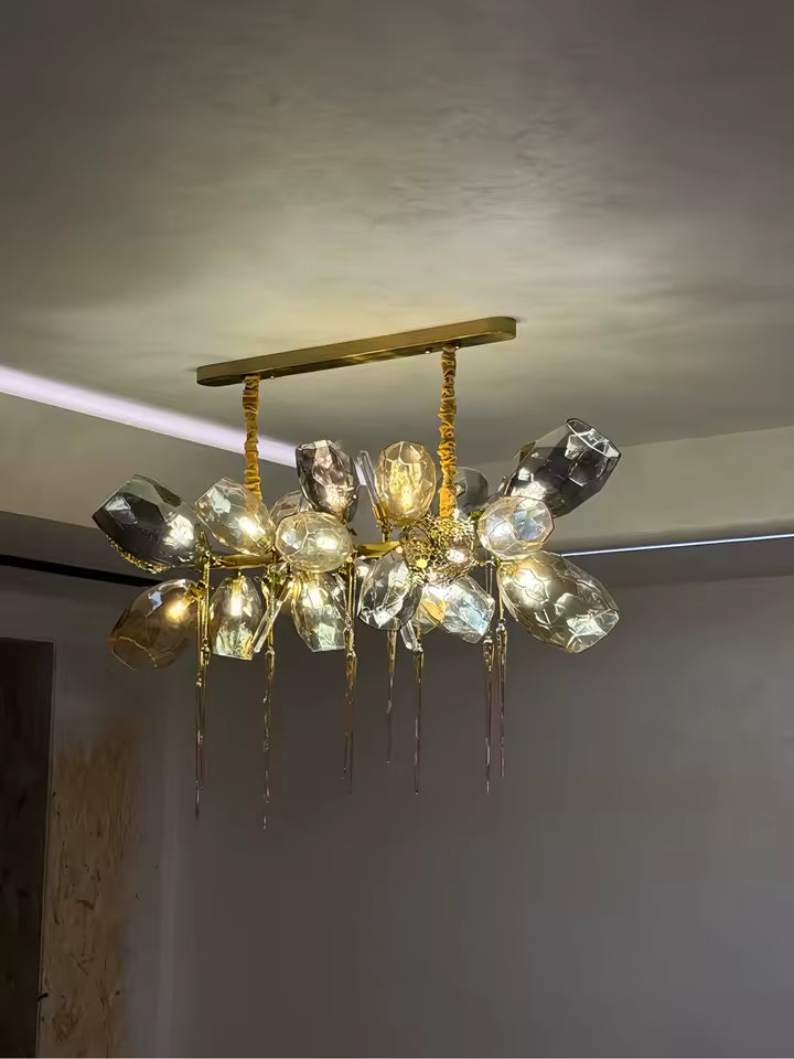 Lustre linéaire en cristal fumé et doré, ponctué de longues pampilles et de facettes lumineuses au style contemporain raffiné.