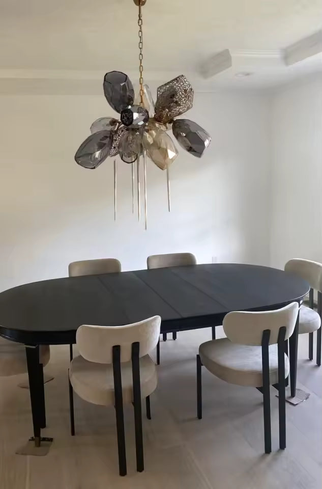 Suspendu au-dessus d’une table de salle à manger, ce lustre en cristal fumé affiche un style élégant et contemporain.