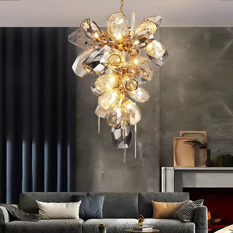 Lustre vertical en cristal fumé et doré, composé de facettes lumineuses et pampilles dans un salon chic contemporain.