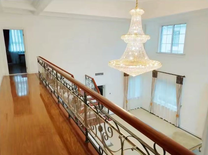 Lustre en cristal pour mezzanine et grande hauteur, style classique luxueux dans un intérieur ouvert et prestigieux.