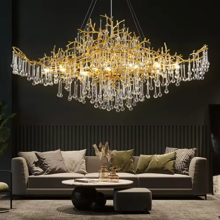 Dans ce salon contemporain, un grand lustre en cristal déploie ses pampilles sur d'élégantes branches dorées sculptées