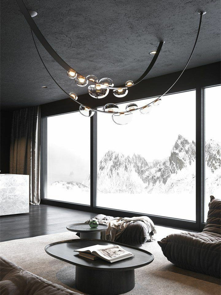 Lustre en cuir noir et sphères lumineuses suspendu dans un vaste loft au style industriel chic.
