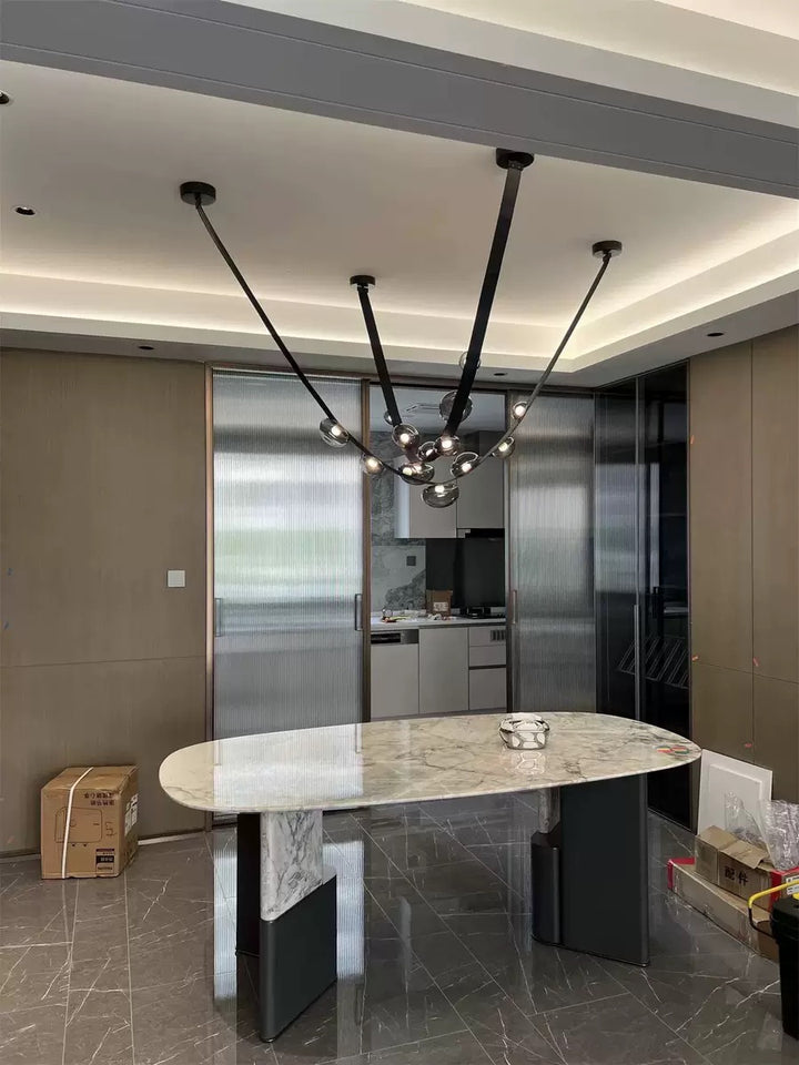 Lustre en cuir et sphères lumineuses suspendu élégamment au-dessus d'une table à manger en marbre.