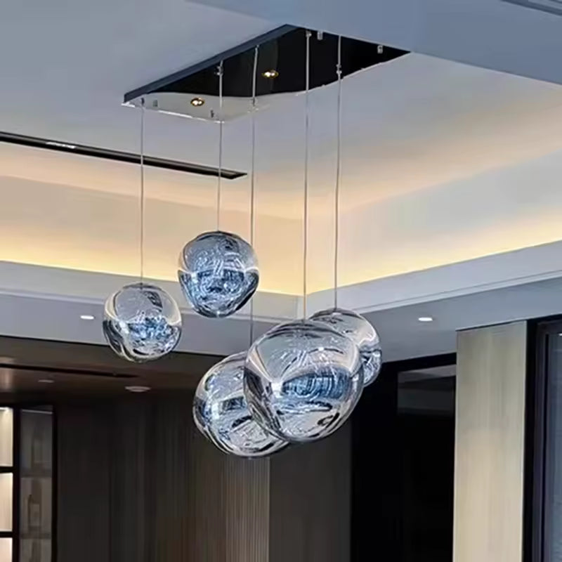 Cinq globes en verre transparent aux reliefs ondulés forment un lustre contemporain aux lignes organiques et reflets cristallins.