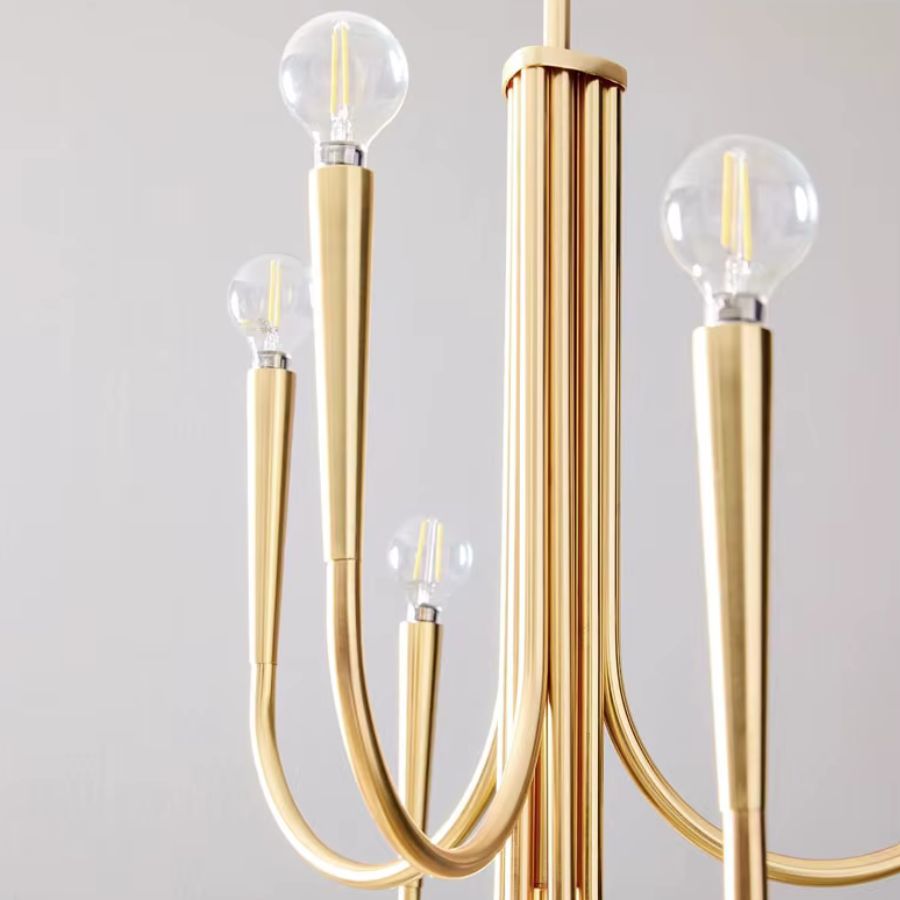 Gros plan sur les bras courbés en métal doré et les ampoules rondes d'un lustre design aux lignes Art déco raffinées.