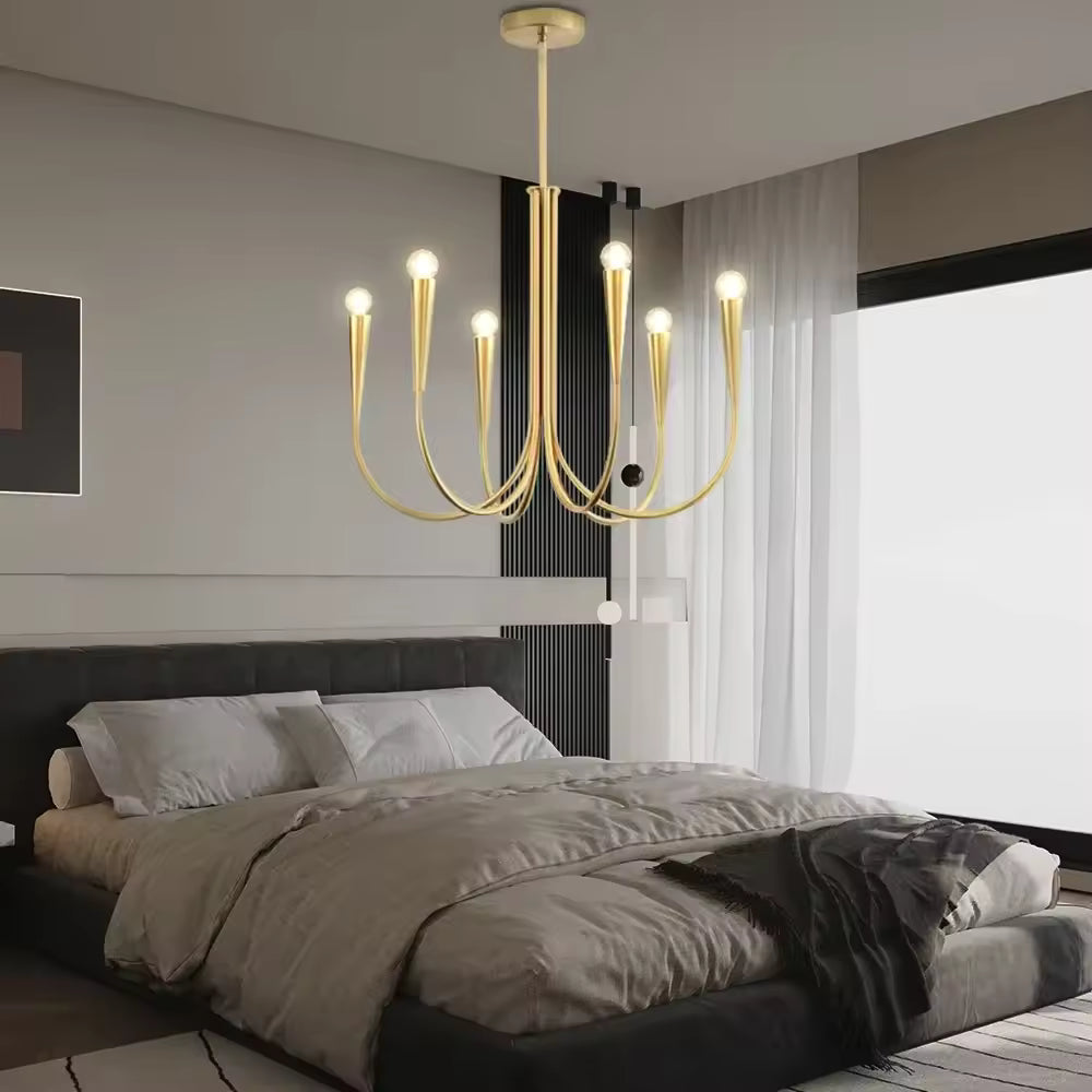 Au-dessus d'un lit double, lustre doré à six bras effilés et ampoules rondes, au style moderne et élégant.