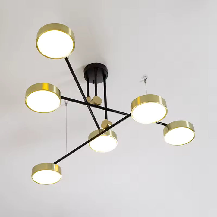 Vue en contre-plongée d’un lustre design aux bras noirs croisés et disques dorés, dans un esprit géométrique moderne.