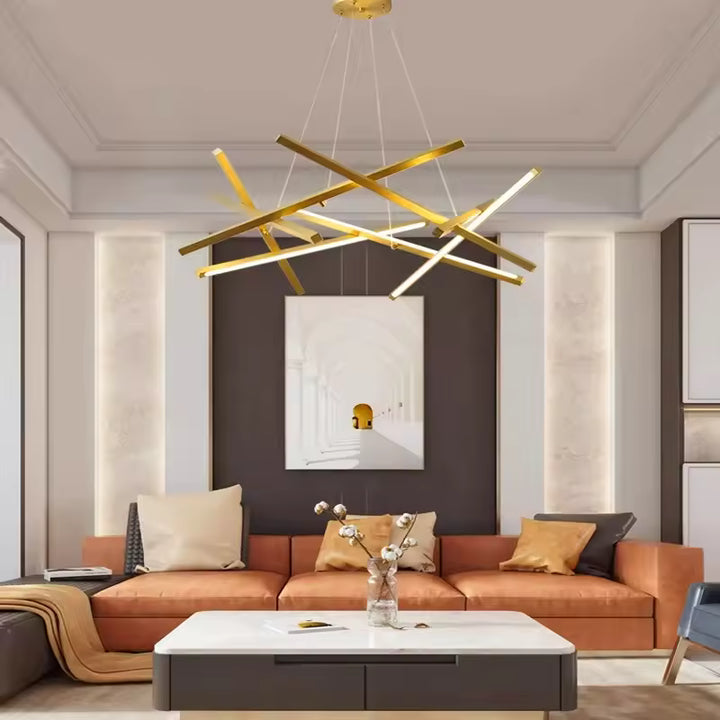 Un lustre doré aux tiges LED entrecroisées surplombe un canapé terracotta dans un salon chic au style contemporain.