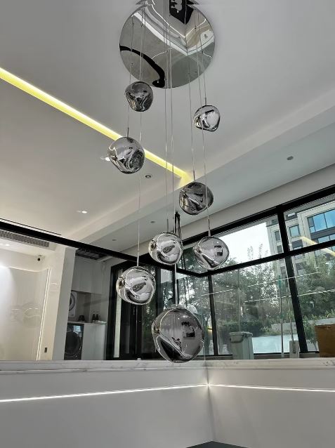 Lustre effet miroir composé de boules suspendues en cascade, idéal pour un escalier ou une entrée à l’esthétique contemporaine.