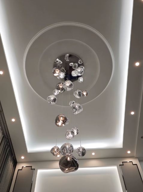 Lustre effet miroir majestueux avec multiples sphères suspendues, idéal pour haut plafond et ambiance luxueuse contemporaine.