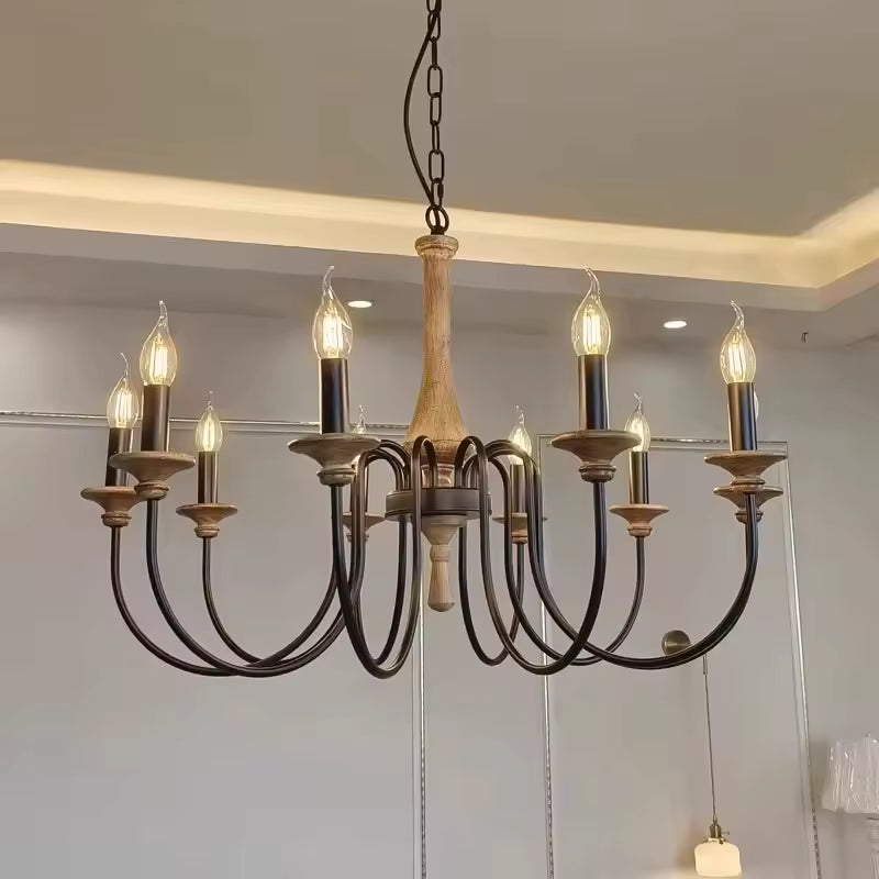 Suspendu dans un intérieur contemporain, ce lustre en bois ancien à 8 bras noirs courbés mêle charme rustique et élégance.