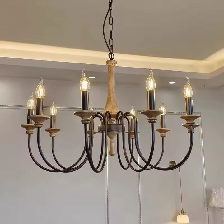 Suspendu dans un intérieur contemporain, ce lustre en bois ancien à 8 bras noirs courbés mêle charme rustique et élégance.