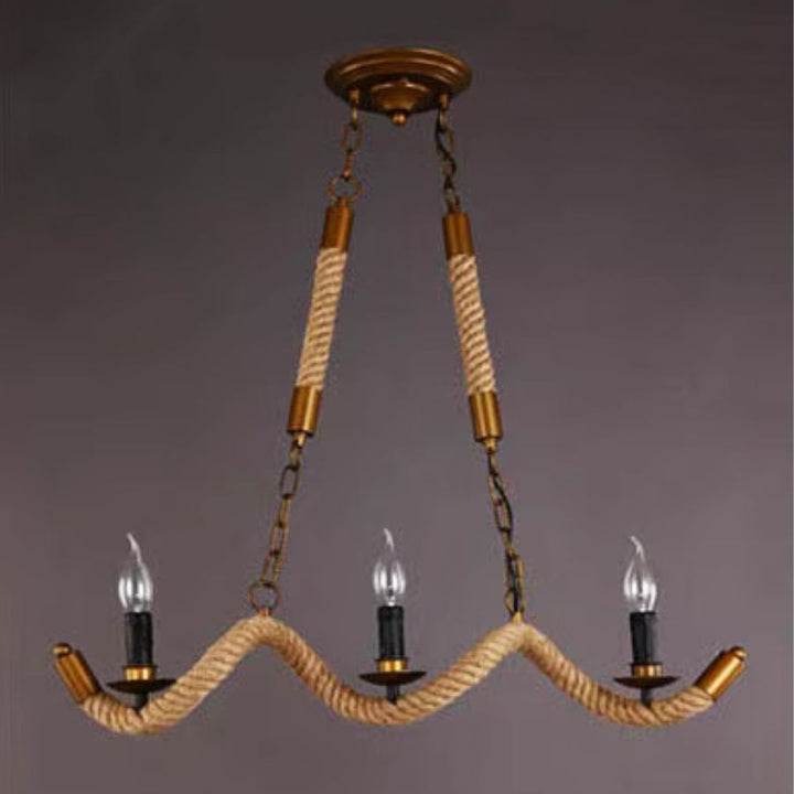 Lustre en corde à trois branches ondulées, suspendu par des chaînes bronze dans un esprit campagne vintage.