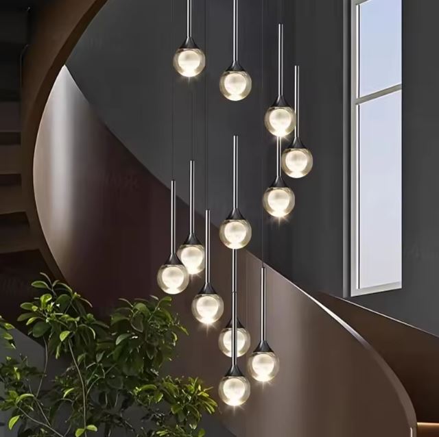 Lustre d’escalier en cascade, globes en verre transparent à cœur opalin, ambiance design élégant.