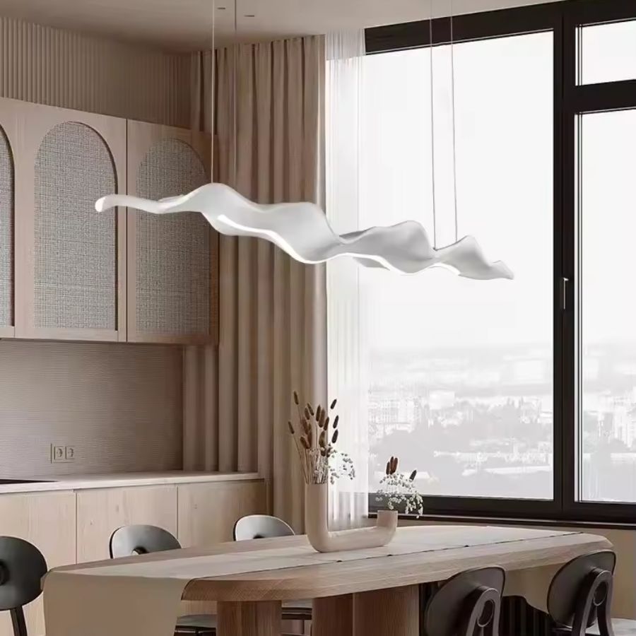 Lustre feuille blanc aux ondulations aériennes, au design minimaliste et organique au-dessus d’une table à manger
