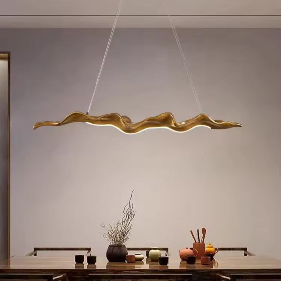 Lustre feuille aux ondulations sculpturales, suspendu au-dessus d’une table dans un intérieur épuré