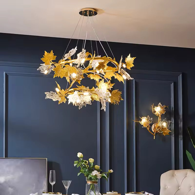 Lustre floral à deux anneaux de feuilles d'érable dorées et en verre sculpté, dans une salle à manger élégante aux murs bleus.