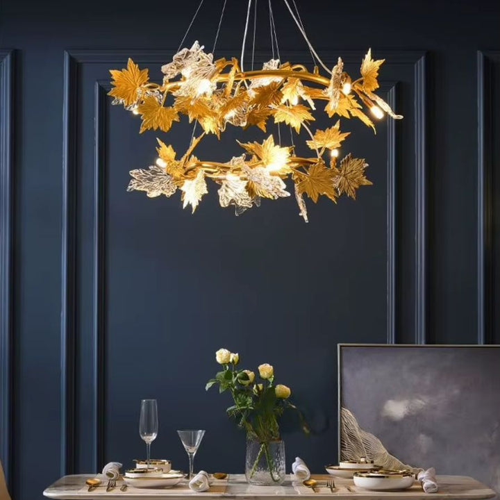 Au-dessus d'une table à manger, un lustre à deux anneaux ornés de feuilles d'érable dorées et en verre évoque l'Art nouveau.