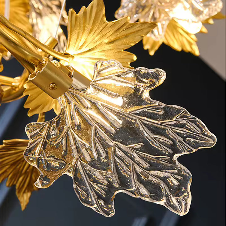Feuille d'érable en verre transparent sculpté, entourée de feuillage doré sur un lustre au design Art nouveau.