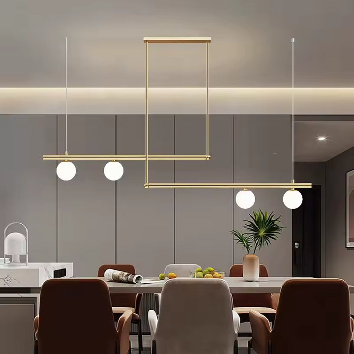 Lustre doré à lignes décalées et 4 globes opalins, structurant une salle à manger contemporaine au style graphique
